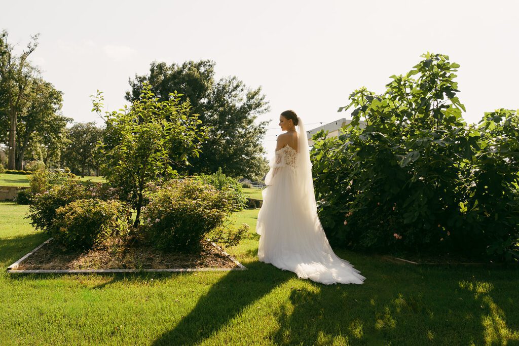 a bride walking through the gardens at the folmar in tyler tx taken by annie austin photography