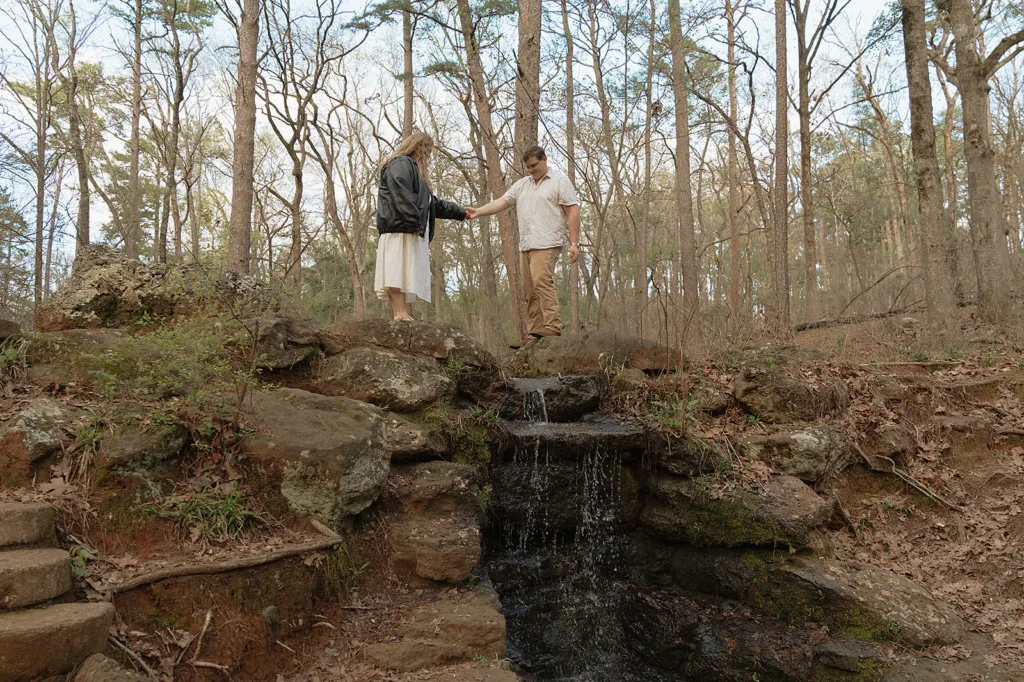 Annie Austin Photography invites you to step into the enchanting piney woods of Tyler, Texas, for an engagement session that echoes your love's natural harmony. With a serene waterfall as your backdrop, let the tranquility of East Texas wrap around your timeless moment, artfully captured in a photograph that celebrates your adventure and affection.