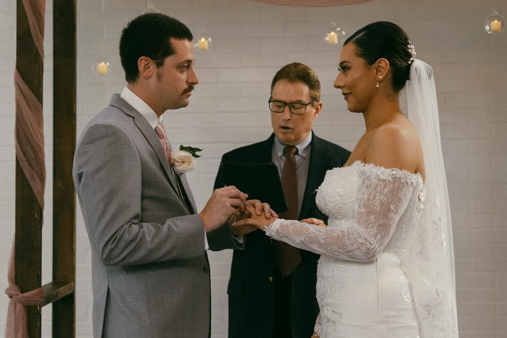 couple exchange rings at their wedding at the grove in tyler texas