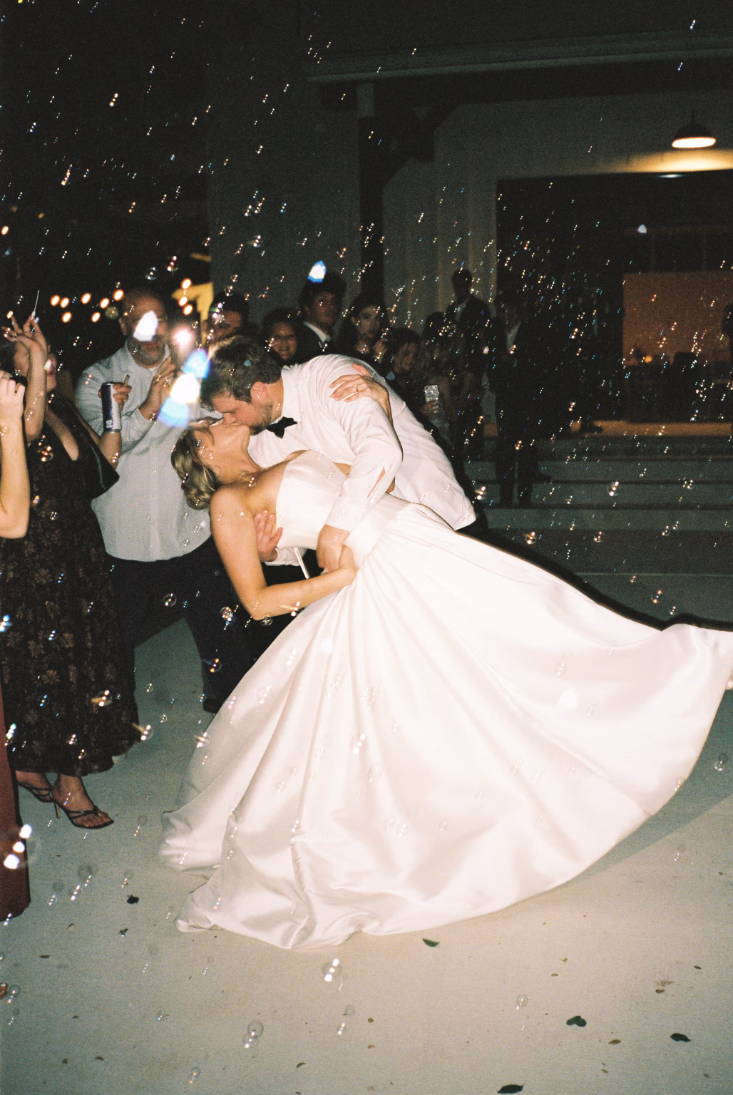 35mm film photo of bride and groom kissing at their bubble exit in their texas wedding