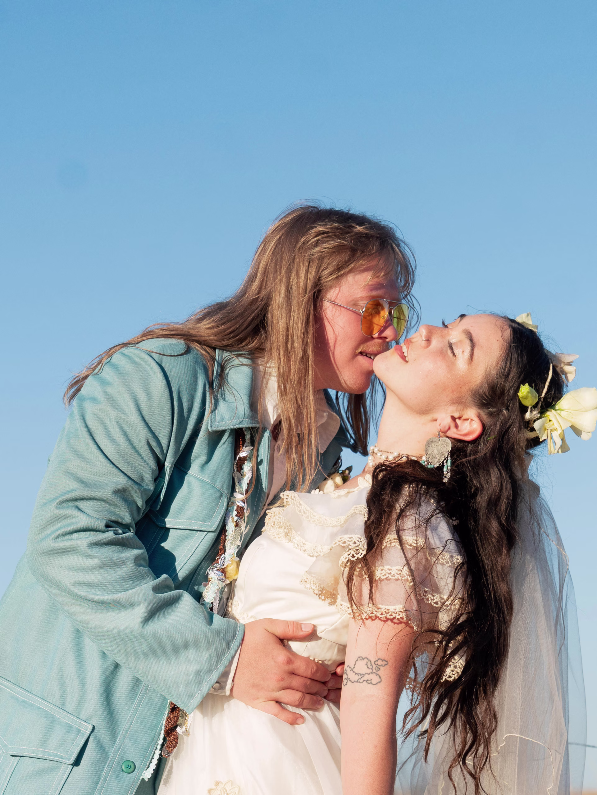 couples portrait in East Texas of a 70's themed wedding outside